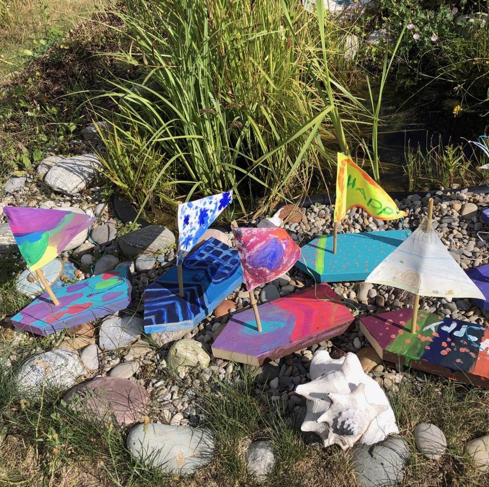 Kinder bauen und bemalen bunte Boote aus Holz